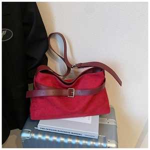 Détails du sac fourre-tout en daim rouge foncé avec boucle métallique et lanières en cuir