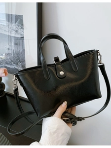 Sac seau en cuir noir brillant avec détails argentés et bandoulière réglable