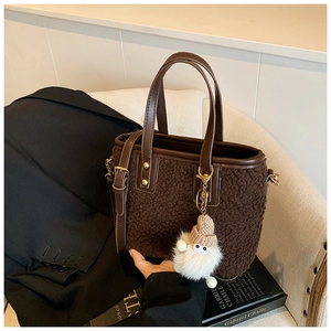 Detail of coffee plush bucket bag with leather handles and cute plush charm pendant