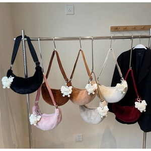 Detail showing plush crescent shoulder bags in multiple colors with fluffy charms