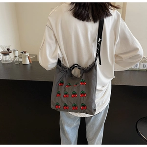 Detailansicht der dunkelgrauen Canvas-Tasche mit Kirschstickerei und schwarzem Kordelzug