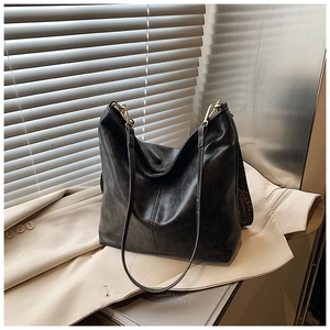 Detail of vintage black bucket bag featuring textured faux leather and patterned strap