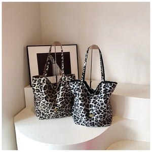Detailed comparison of brown and black leopard print tote bags on minimalist stands