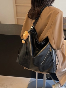 Women's black vintage leather tote bag with a cute bear charm and gold zippers