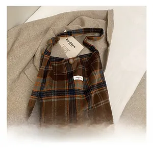 Détail du sac cabas à carreaux multicolores avec fermeture boutonnée et étiquette