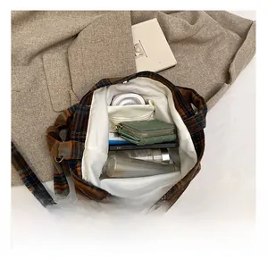 Vue interne montrant la grande capacité et la poche zippée du sac fourre-tout à carreaux
