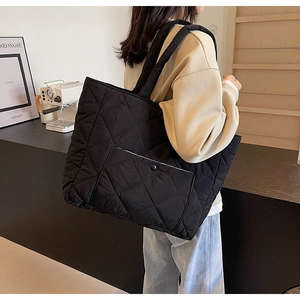 Macro shot of black quilted tote bag texture with minimalist diamond stitching details
