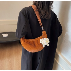 Caramel faux fur crescent shoulder bag with wide strap and cute plush charm detail