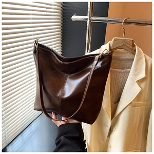 Detail view of smooth dark brown leather hobo bag with sleek gold metal hardware