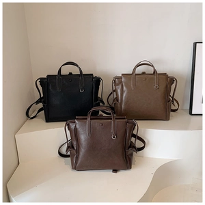 Detailed view of vintage laptop bags with contrast stitching and metal ring decor