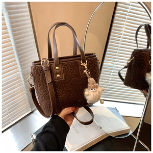 Detail of brown teddy fleece tote bag with smooth leather handles and plush dwarf charm
