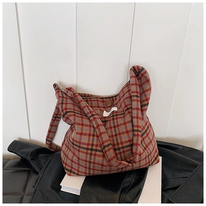 Détail de la texture laine et fermeture à bouton du sac cabas rétro à carreaux