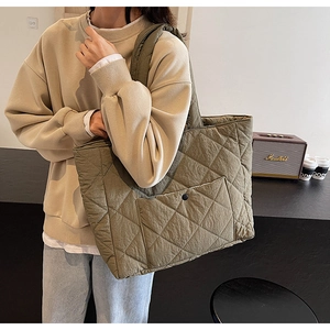 Detailed view of the large olive green quilted tote bag with diamond stitching and front pocket