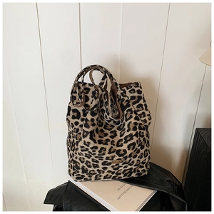 Detail of trendy leopard print tote bag with soft canvas texture and metal logo