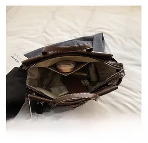 Macro view of spacious interior with contrast stitching on dark brown leather briefcase
