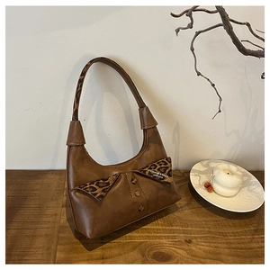 Close-up of retro brown shoulder bag with leopard print lapel detail and buttons
