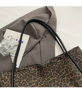 Détail du sac cabas à imprimé léopard avec bandoulières noires et texture en tissu épais