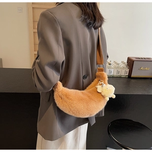 Detail of plush crescent shoulder bag with brown soft texture and adjustable wide strap