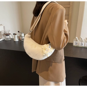 Detailed side view of white plush crescent bag with cute lamb pendant and adjustable strap