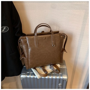 Brown vintage leather backpack shown on silver suitcase for business travel context
