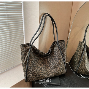 Vue détaillée du sac cabas à imprimé léopard avec anses en cuir noir en décor de style