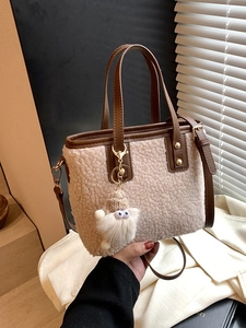 Beige fleece bucket bag with brown leather trim and plush doll charm for autumn winter