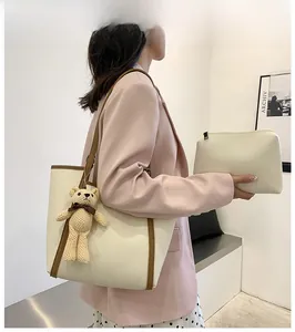 Detailed view of beige tote bag set with brown trim and cute woven bear charm