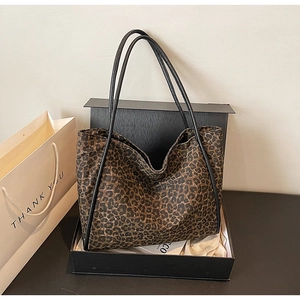 Gros plan d'un sac cabas léopard dans une boîte cadeau noire avec une carte de remerciement