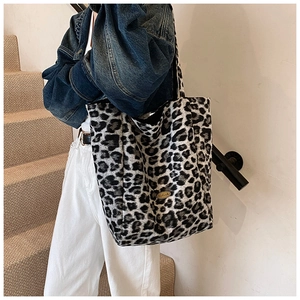 Detail of leopard print tote bag with gold handmade metal plaque and soft texture