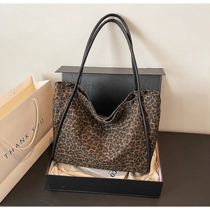 Détail du sac cabas à imprimé léopard avec anses noires présenté dans un coffret cadeau