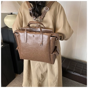 Detail of vintage brown leather backpack with white stitching and convertible straps