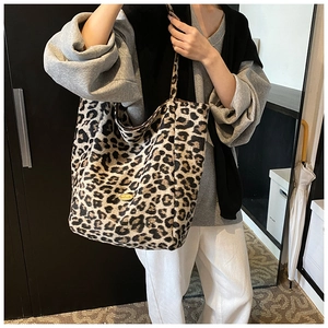 Detail of large leopard print canvas tote bag with a golden handmade metal tag