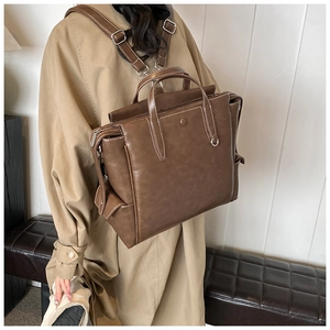 Detail of vintage brown PU leather backpack with contrast stitching and side snap pocket