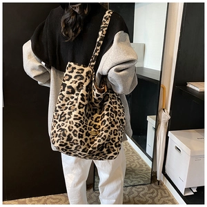 Detail of leopard print tote bag featuring a handmade metal plate and soft texture