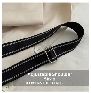 Detail of adjustable black woven shoulder strap with white stripes and silver buckle