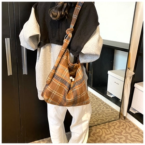 Détail du sac cabas rétro à carreaux avec bandoulière nouée et texture en tissu épais