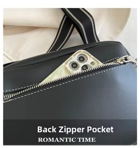 Close-up of black crossbody bag back zipper pocket fitting a smartphone