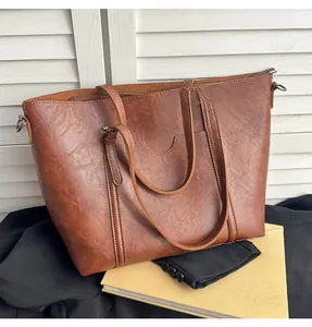Detail of vintage brown faux leather tote bag with long straps and smooth zipper closure