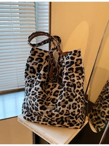 Chic leopard print bucket bag with handmade metal logo and plush velvet finish