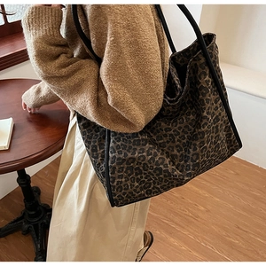 Gros plan d'un sac cabas à imprimé léopard avec des anses noires en intérieur doux