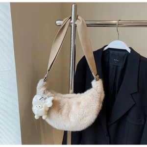 Close-up of beige plush half-moon crossbody bag with soft texture and fairy bag charm