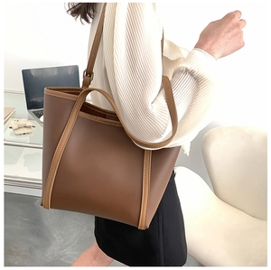 Detailed macro view of high-quality brown contrast faux leather texture on the tote bag