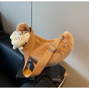 Close-up of caramel plush hobo bag with furry texture and wide textile shoulder strap