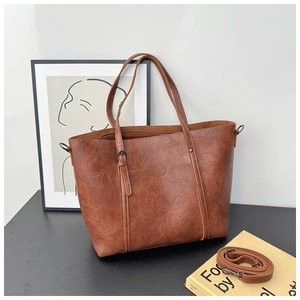 Detail of a brown vintage tote bag showing its textured PU leather and stylish buckle design