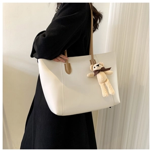 White large capacity tote bag with brown straps and cute bear charm shown on shoulder