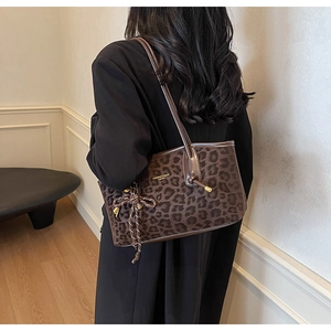 Détail du sac cabas léopard avec texture daim et logo de la marque sur l'épaule