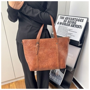 Detail view of vintage dark brown tote bag with natural leather texture and front pocket