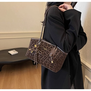 Gros plan du sac cabas rétro à imprimé léopard avec lettrage doré et charme à pompon
