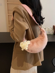 Pink plush crescent shoulder bag with soft faux fur texture and a cute charm