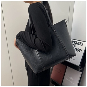 Detail view of black vintage tote bag with PU leather texture and silver rivets